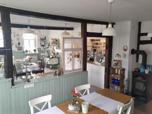 a dining room with two tables and a kitchen at Pension Gute Stube in Sulzfeld (im Grabfeld) +17 photos