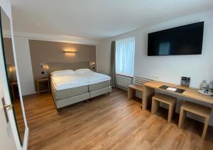 a bedroom with a bed and a desk and a television at Hotel Artist in Biel
