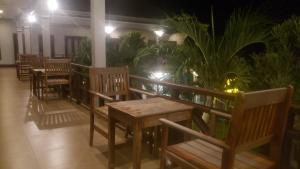 a row of benches and tables in a room with plants at Mama Leurth Sunset Guesthouse in Don Det