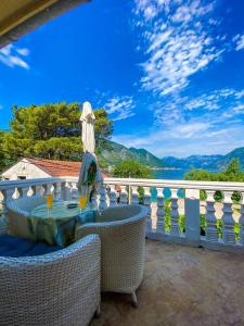 a patio with a table and chairs on a balcony at lovely apartment on the sea shore, with a view and free Wi-Fi in Kotor