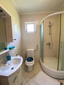 a bathroom with a sink and a toilet and a shower at lovely apartment on the sea shore, with a view and free Wi-Fi in Kotor