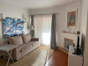 uma sala de estar com um sofá e uma janela em Quinta do lago & golf na Quinta do Lago