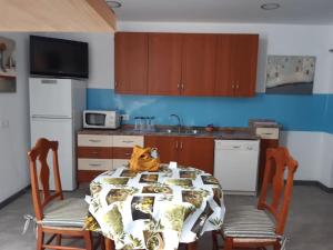 a kitchen with a table and two chairs and a kitchen with a kitchen at Casa llena de vida con patio y terraza in Coín