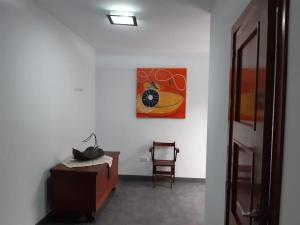 a bedroom with a bed and a chair and a painting at Casa llena de vida con patio y terraza in Coín