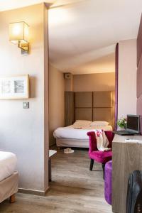 een hotelkamer met een bed, een bank en een stoel bij Le Trèfle in Portet-sur-Garonne