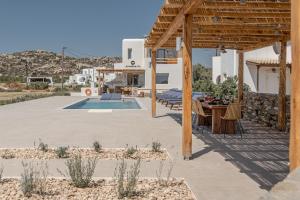 a patio with a table and a house with a pool at Villa Armelina in Plaka