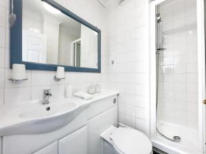 W łazience znajduje się umywalka, toaleta i lustro. w obiekcie LUXURIOUS Terrace 2 Bedrooms in Relaxing Covent Garden Apartment w Londynie