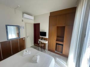 a bedroom with a bed and a desk and a television at Hotel Metropol in Pesaro