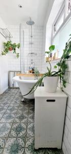 a bathroom with a tub with plants on the floor at Stylish 3 Bedroom Townhouse in Brockley with Large Garden in London