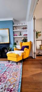 a living room with a yellow couch and a rug at Stylish 3 Bedroom Townhouse in Brockley with Large Garden in London