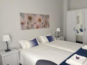- une chambre avec un grand lit blanc orné d'une peinture murale dans l'établissement El Angliru 3 con Wifi Incluido, à Castandiello