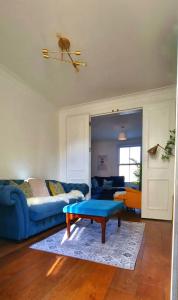 a living room with a blue couch and a table at Stylish 3 Bedroom Townhouse in Brockley with Large Garden in London