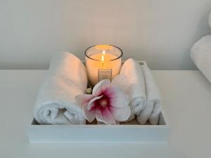 een kaars, handdoeken en een bloem op een plank bij stilvolle Ferienwohnung Sweet Magnolia in Kühlungsborn +31 foto's