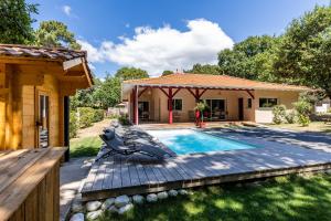 une arrière-cour avec une piscine et une maison dans l'établissement Villa Tilé Lanton, à Lanton