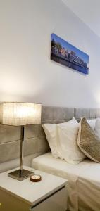 a bedroom with a bed and a table with a lamp at Cantinho do Auka - Studio in Aveiro