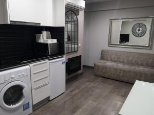 sala de estar con lavadora y sofá en ApartEasy - Eixample Center en Barcelona