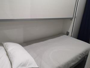 Cama en habitación pequeña con colchón blanco en ApartEasy - Eixample Center en Barcelona