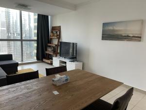 a living room with a wooden table and a television at [METRO] Premium Location Lovely 2 Bedroom In JLT in Dubai