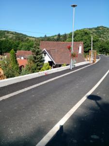 uma estrada vazia com casas e uma luz de rua em Skriveni raj em Vrdnik