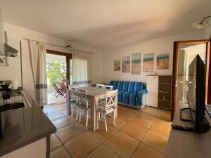 Una cocina y una sala de estar con una mesa y un sofá. en House 40 in Capannizza Pool Complex next the beach, en Budoni