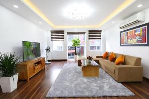 a living room with a couch and a tv at Sumitomo luxury apartment hotel near Lotte in Hanoi
