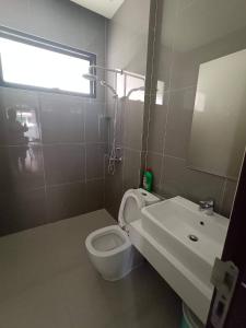 a bathroom with a toilet and a sink and a window at The Encore Hotel in Pattaya South