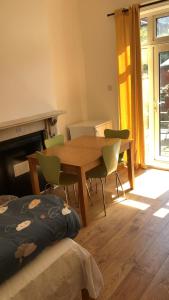 a dining room with a wooden table and chairs at Burney Tomar House in Croydon