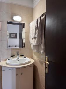 a bathroom with a sink and a mirror at GRAND Boutique Studios in Afissos