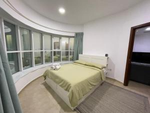 a bedroom with a bed and a large window at Near Metro - Lovely Modern 1 Bedroom in JLT in Dubai