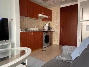 a kitchen with a washer and dryer in a room at Near Metro - Lovely Modern 1 Bedroom in JLT in Dubai