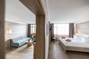 バート・グリースバッハにあるAktiVital Hotelのベッドとソファ付きのホテルルーム