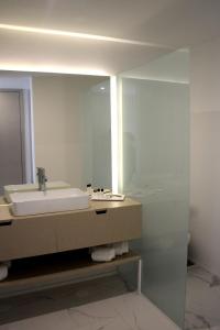 y baño con lavabo y espejo. en Hotel & Spa Alfandega da Fe, en Sambade