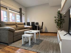 a living room with a couch and a table at MSuites Viveiro in Viveiro