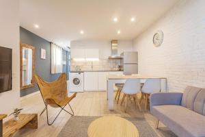 Una sala de estar y una cocina con mesa y sillas. en Bird House, en Barcelona