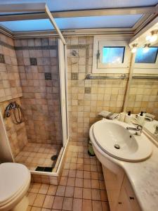 uma casa de banho com um chuveiro, um lavatório e um WC. em Beautiful Seaside Studio em Akrata