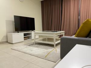 a living room with a television and a white table at METRO Premium Location Spacious 2 Bedroom Apartment Right Next to the Metro in Dubai