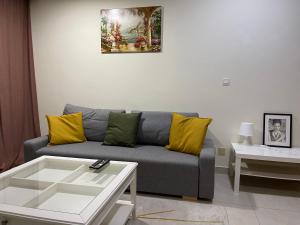 a living room with a gray couch and yellow pillows at METRO Premium Location Spacious 2 Bedroom Apartment Right Next to the Metro in Dubai