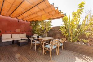 una terraza de madera con mesa, sillas y sombrilla en Bird House, en Barcelona