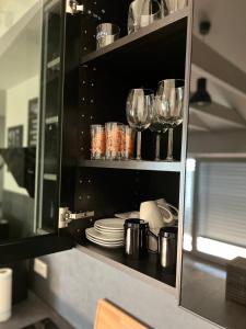 una cocina con copas de vino y platos en un armario en Loft Wohnung Appartement auf 2 Etagen, Nähe Neckar, en Neckarwestheim