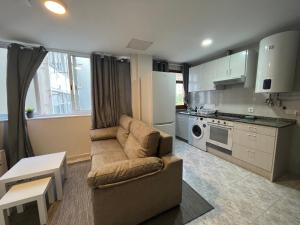 a living room with a couch and a kitchen at MSuites Viveiro in Viveiro