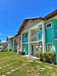 a row of apartment buildings with a yard at Apartamento 10 - Praia Taperapuã- BA- Próximo ao Axé Moi -até 8 pessoas in Porto Seguro