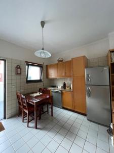 a kitchen with a table and a stainless steel refrigerator at A Casa da Maria in Horta