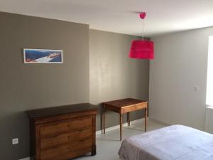 Gîte de la Collonge في Ambierle: غرفة نوم بسرير وخزانة وطاولة