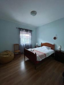 una camera con un letto e una sedia e una finestra di A Casa da Maria a Horta