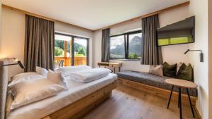 a bedroom with a bed and a tv and windows at Im Wiesengrund Apartments in Sesto
