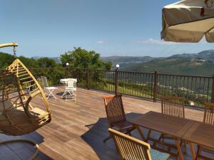 a deck with a table and chairs and an umbrella at Arcadia in Secadura