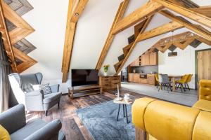 a living room with a yellow couch and a tv at Apartamenty Polana pod Nosalem - zachód in Zakopane
