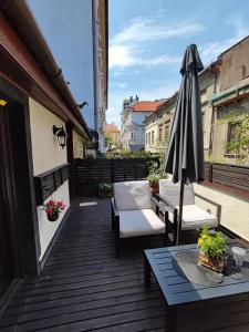 a patio with an umbrella and chairs and a table at Apartament Podcienie z tarasem Bielsko-Biała Old Town in Bielsko-Biała