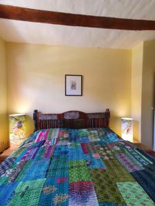 a bedroom with a bed with a colorful quilt at BlaukehlchenBleibe in Groß Nemerow