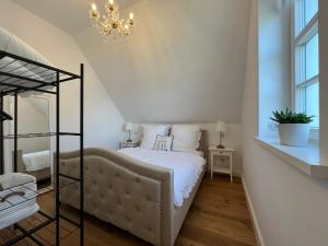 Schlafzimmer mit einem Bett und einem Kronleuchter in der Unterkunft stilvolle Ferienwohnung Sweet Magnolia in Kühlungsborn